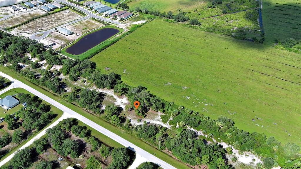 An aerial view shows a vacant, wooded lot marked by a pin near a road — 13441 GREEN GULF BOULEVARD, PUNTA GORDA, FL