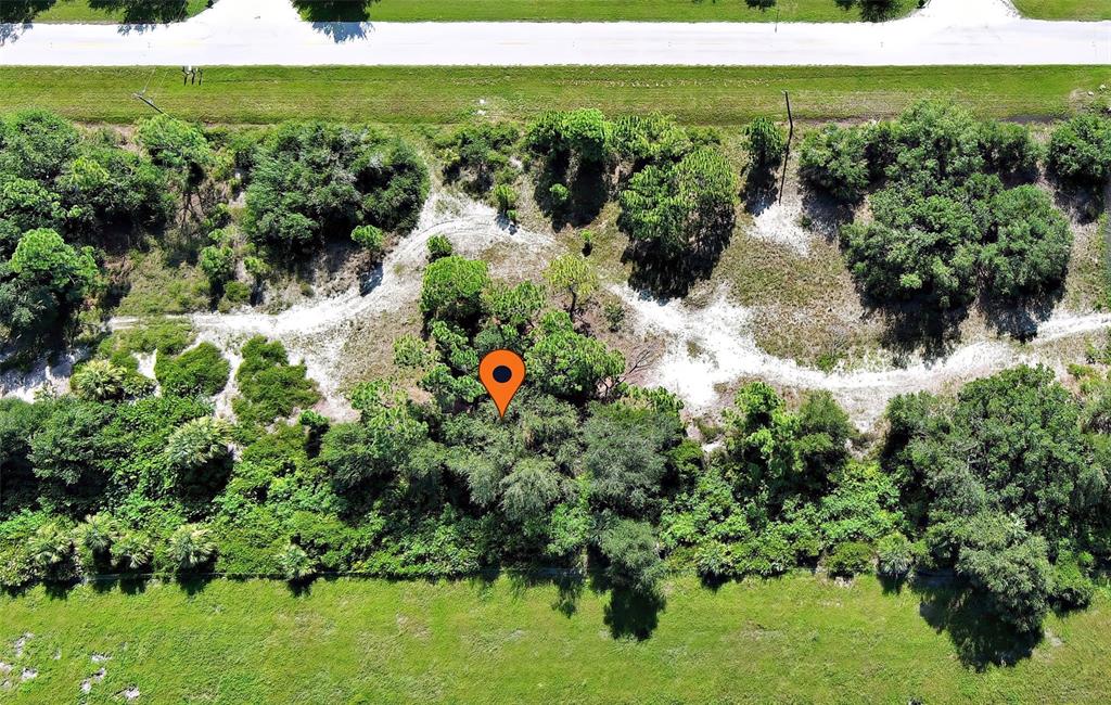 An aerial view shows a wooded, undeveloped lot with a location pin and nearby road — 13441 GREEN GULF BOULEVARD, PUNTA GORDA, FL