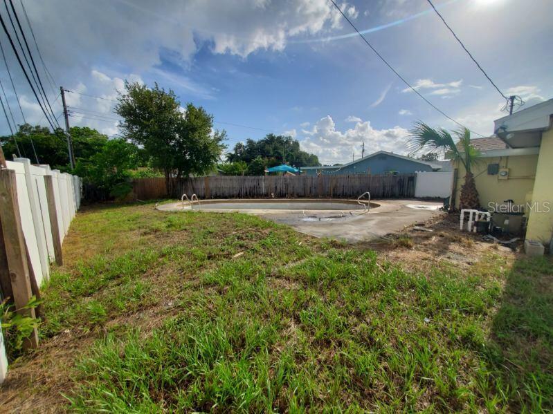 A light yellow house exterior features a front door with a blue-paned window and siding — 9956 136TH STREET, SEMINOLE, FL
