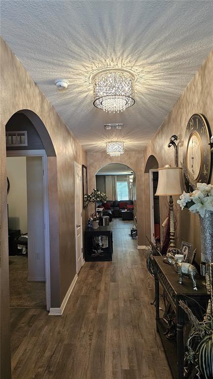 A hallway features wood-look flooring, arched doorways, decorative light fixtures, and a console table — 2459 VALHALLA DRIVE, TAVARES, FL