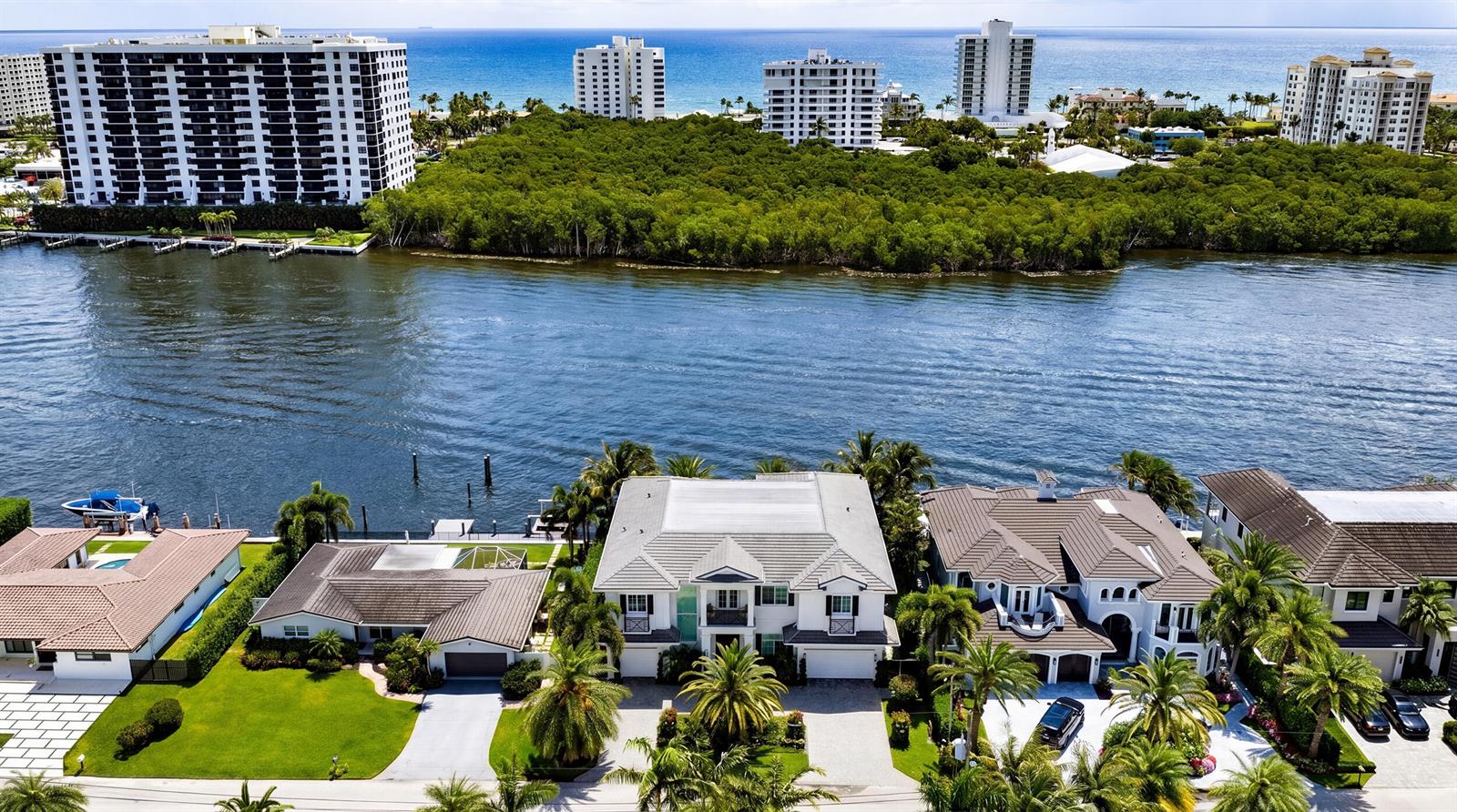 An aerial view shows waterfront homes with pools and palm trees along a wide canal — 7212 NE 8th Drive, Boca Raton FL 33487, BOCA RATON, FL