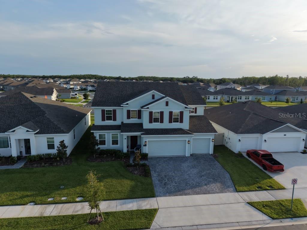 An aerial view shows a two-story suburban house with a paved driveway and attached garage — 4170 GOOSEBERRY TRAIL, KISSIMMEE, FL