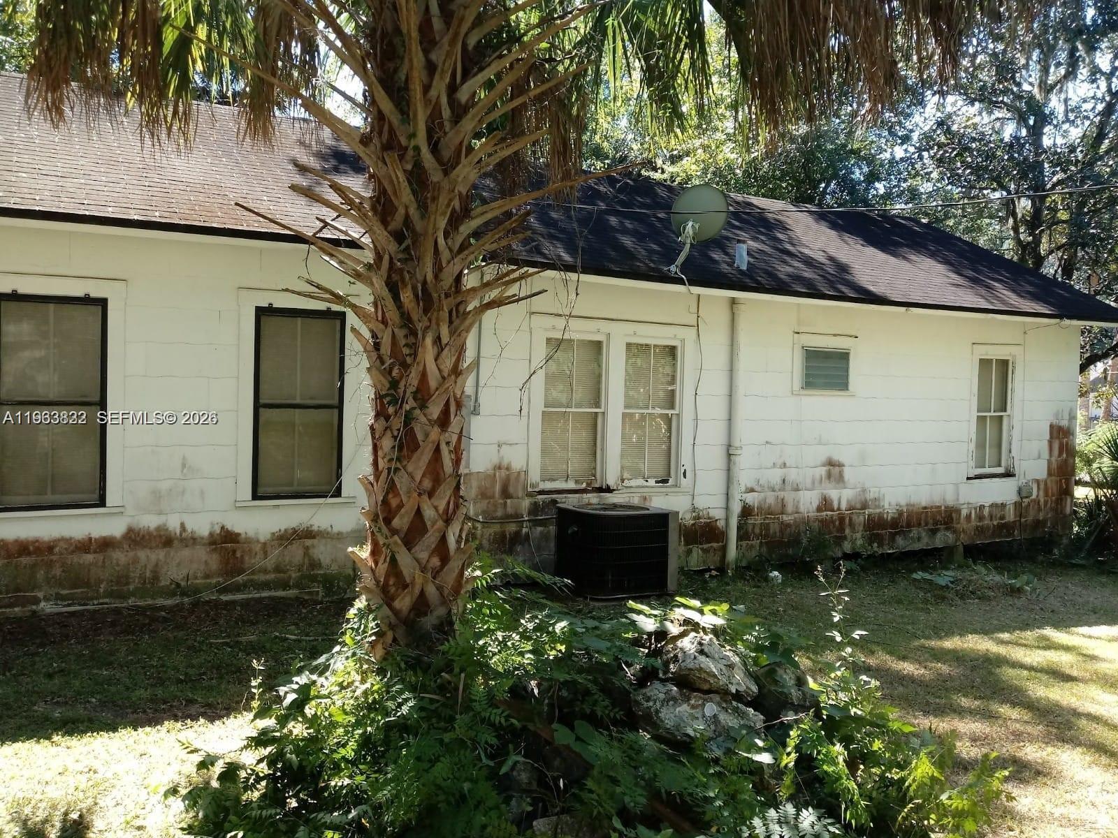 The exterior of a white house features a palm tree and a central air conditioning unit — 331 NE 9 AVE, Ocala FL 34470, OCALA, FL