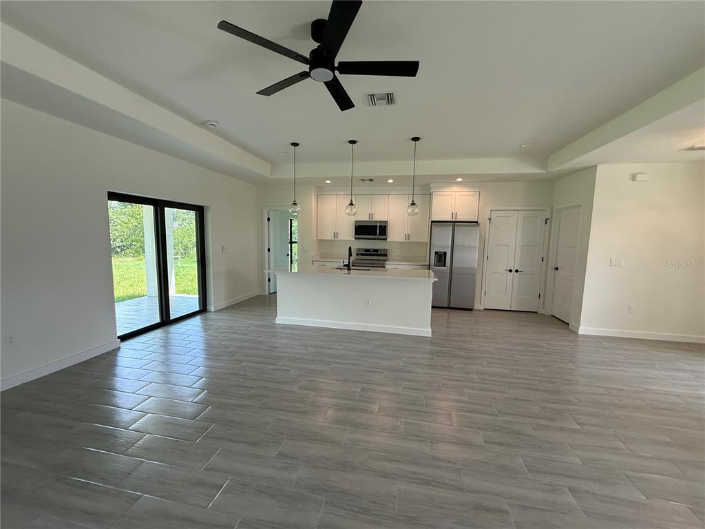 An open-concept kitchen features white cabinetry, stainless steel appliances, and a central island — 3764 CINDERELLA ROAD, NORTH PORT, FL