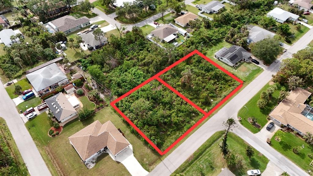 An aerial view shows two adjacent, undeveloped rectangular lots outlined in red within a neighborhood — LOTS 3115 & 3116 CYPRESS ROAD, VENICE, FL
