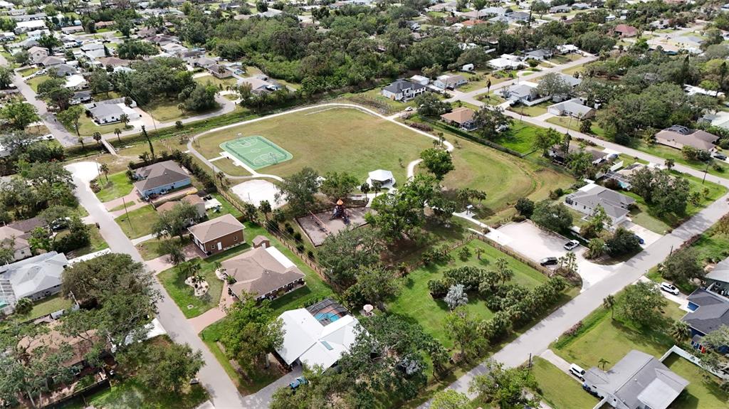An aerial view shows a neighborhood park with a basketball court, playground, and surrounding houses — LOTS 3115 & 3116 CYPRESS ROAD, VENICE, FL