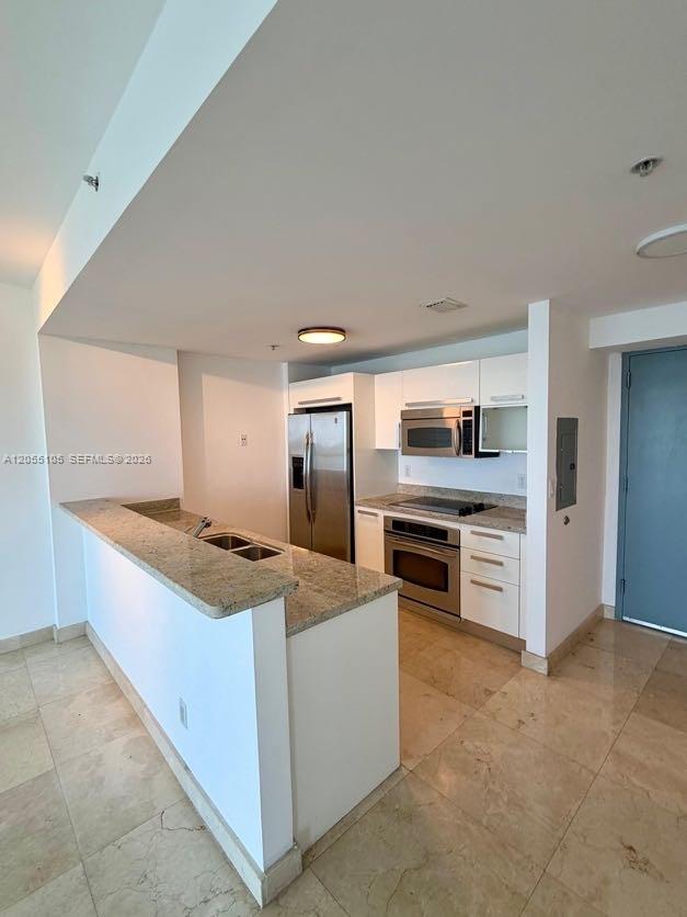A kitchen features white cabinets, stainless steel appliances, and a granite-topped breakfast bar — 601 NE 36th St # 1311, Miami FL 33137, MIAMI, FL