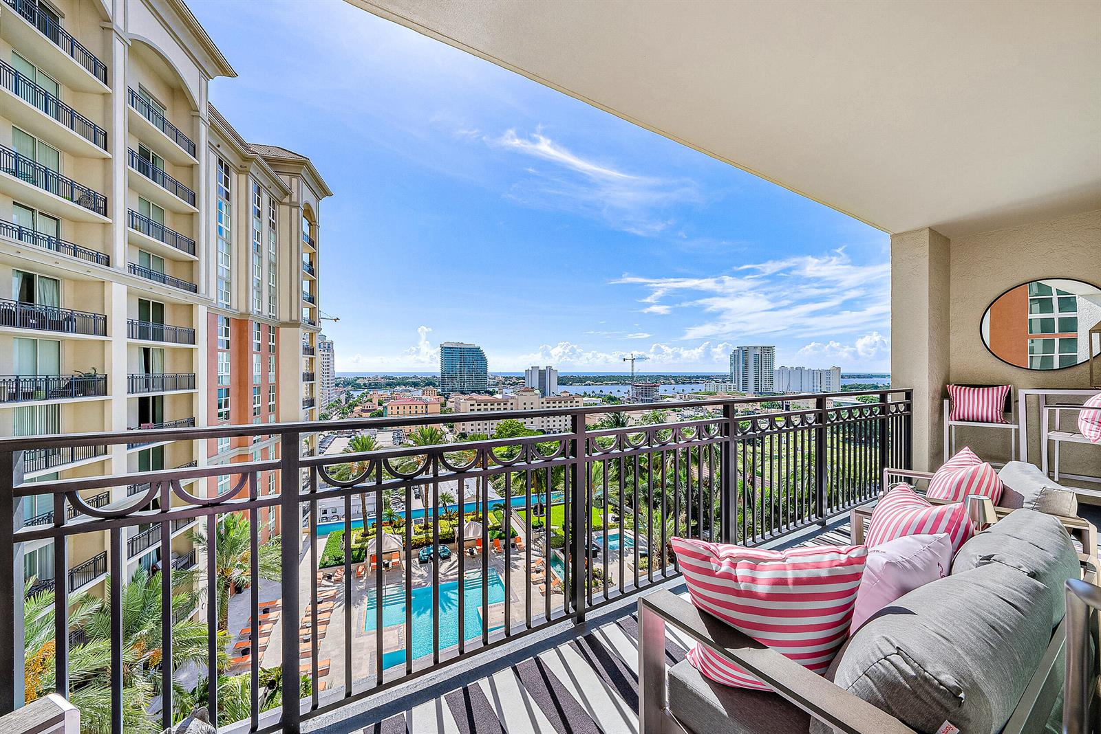 A balcony with outdoor seating overlooks a swimming pool and a city skyline — 550 Okeechobee Boulevard # 1615, West Palm Beach FL 33401, WEST PALM BEACH, FL
