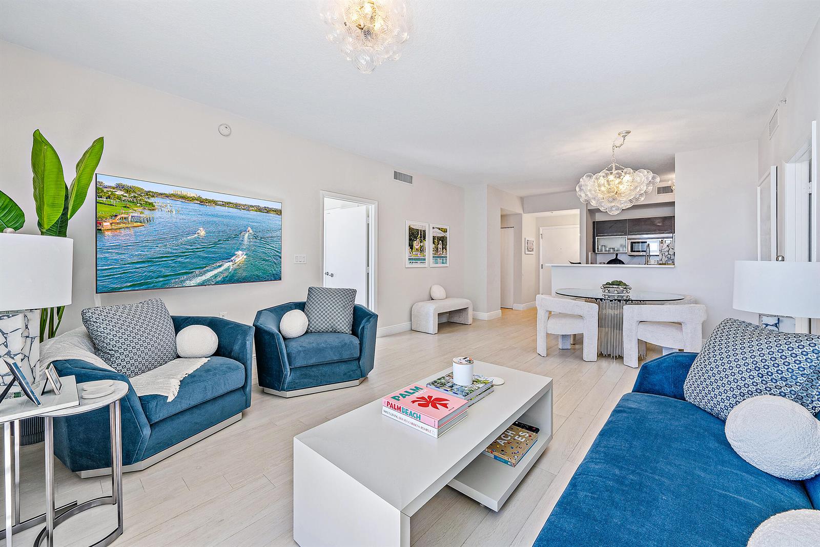 A living room with blue furniture, a white coffee table, and an open kitchen area — 550 Okeechobee Boulevard # 1615, West Palm Beach FL 33401, WEST PALM BEACH, FL