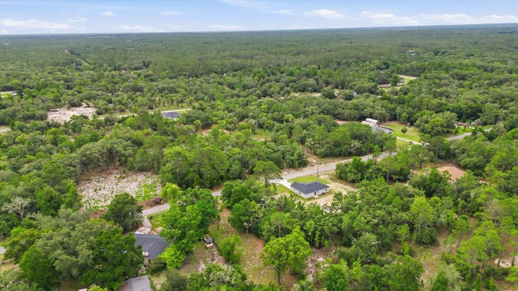 An aerial view shows several houses scattered among dense trees and rural roads — 0000 SW SANDS PT AVE LOT 32, DUNNELLON, FL