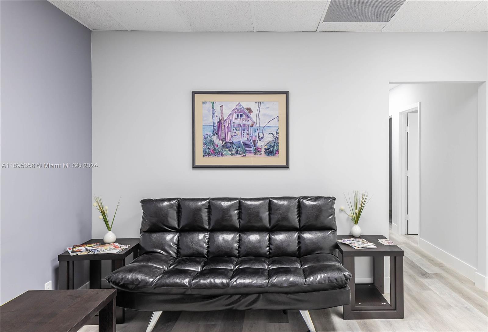 A waiting room features a black tufted sofa, two side tables, and a framed painting — 2500 E Hallandale Beach Blvd, Hallandale Beach FL 33009, HALLANDALE BEACH, FL