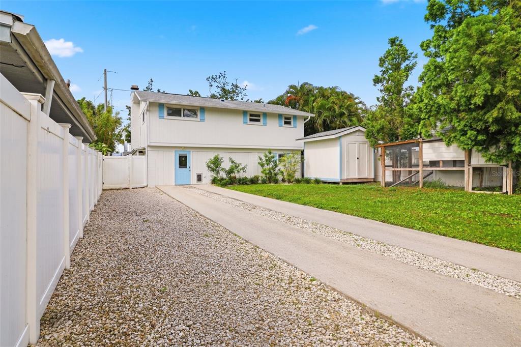 A two-story house with a light blue door, a concrete driveway, and a backyard shed — 7 GEORGIA AVENUE, CRYSTAL BEACH, FL