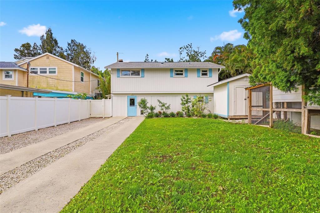 A two-story house with white siding, a blue door, a concrete driveway, and a lawn — 7 GEORGIA AVENUE, CRYSTAL BEACH, FL