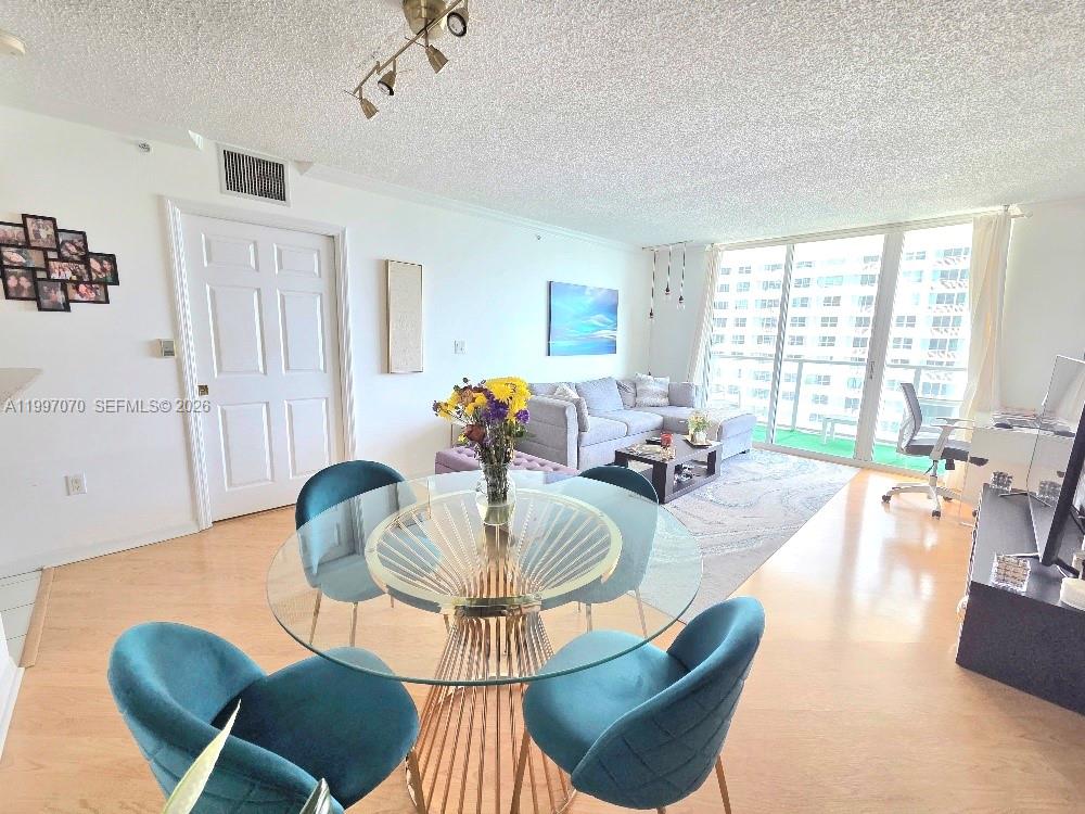 An empty room with light wood flooring, white walls, and floor-to-ceiling windows overlooking a bay — 1155 Brickell Bay Dr # 2006, Miami FL 33131, MIAMI, FL