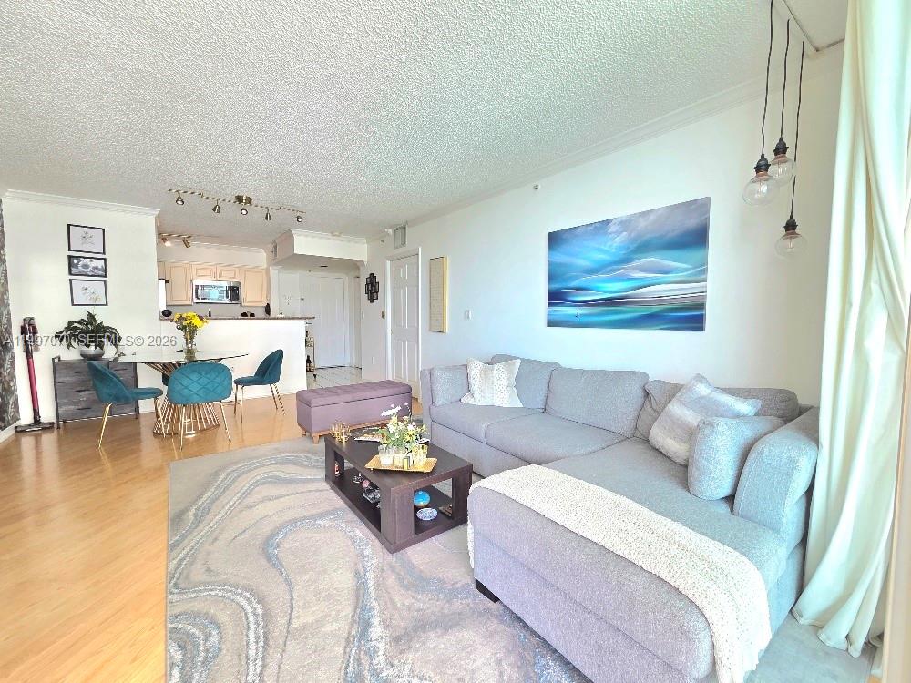 An empty room with light wood floors, a popcorn ceiling, and a balcony overlooking water — 1155 Brickell Bay Dr # 2006, Miami FL 33131, MIAMI, FL
