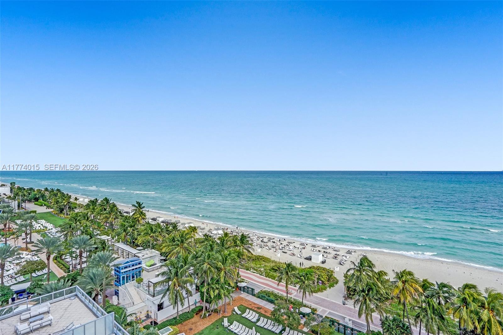 An elevated view shows a sandy beach, palm trees, and the ocean under a clear sky — 4391 Collins Ave, Miami Beach FL 33140, MIAMI BEACH, FL