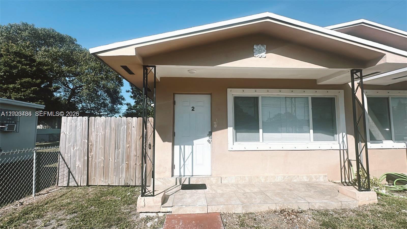 The exterior of a single-story house features a tiled porch, a white door, and metal supports — 2125 NW 66th St # 2, Miami FL 33147, MIAMI, FL