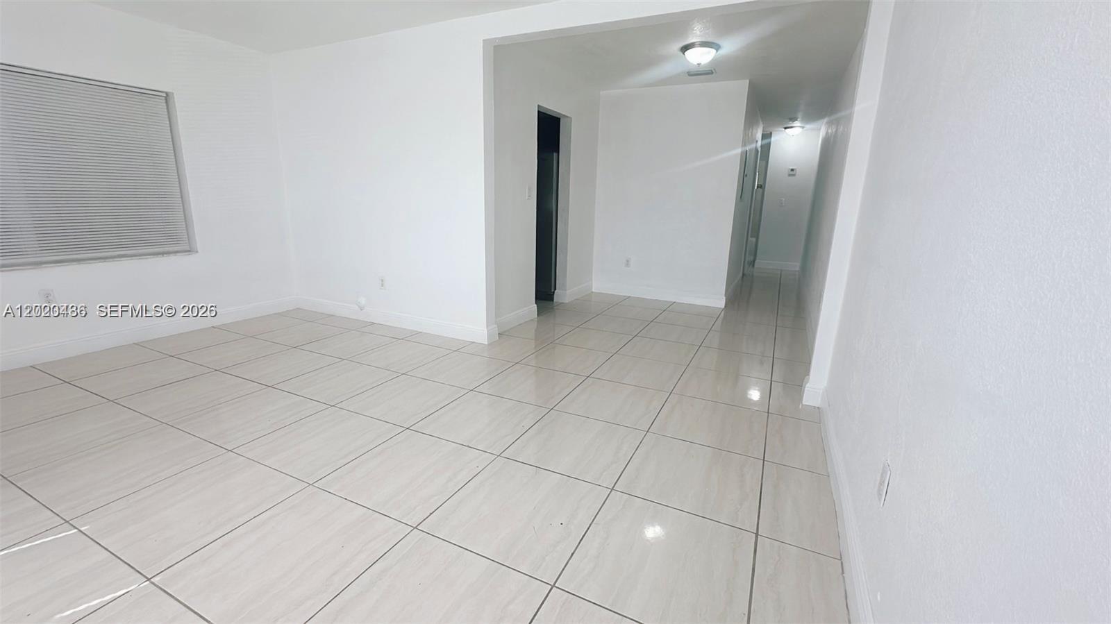 An empty room features white walls and light-colored square floor tiles — 2125 NW 66th St # 2, Miami FL 33147, MIAMI, FL