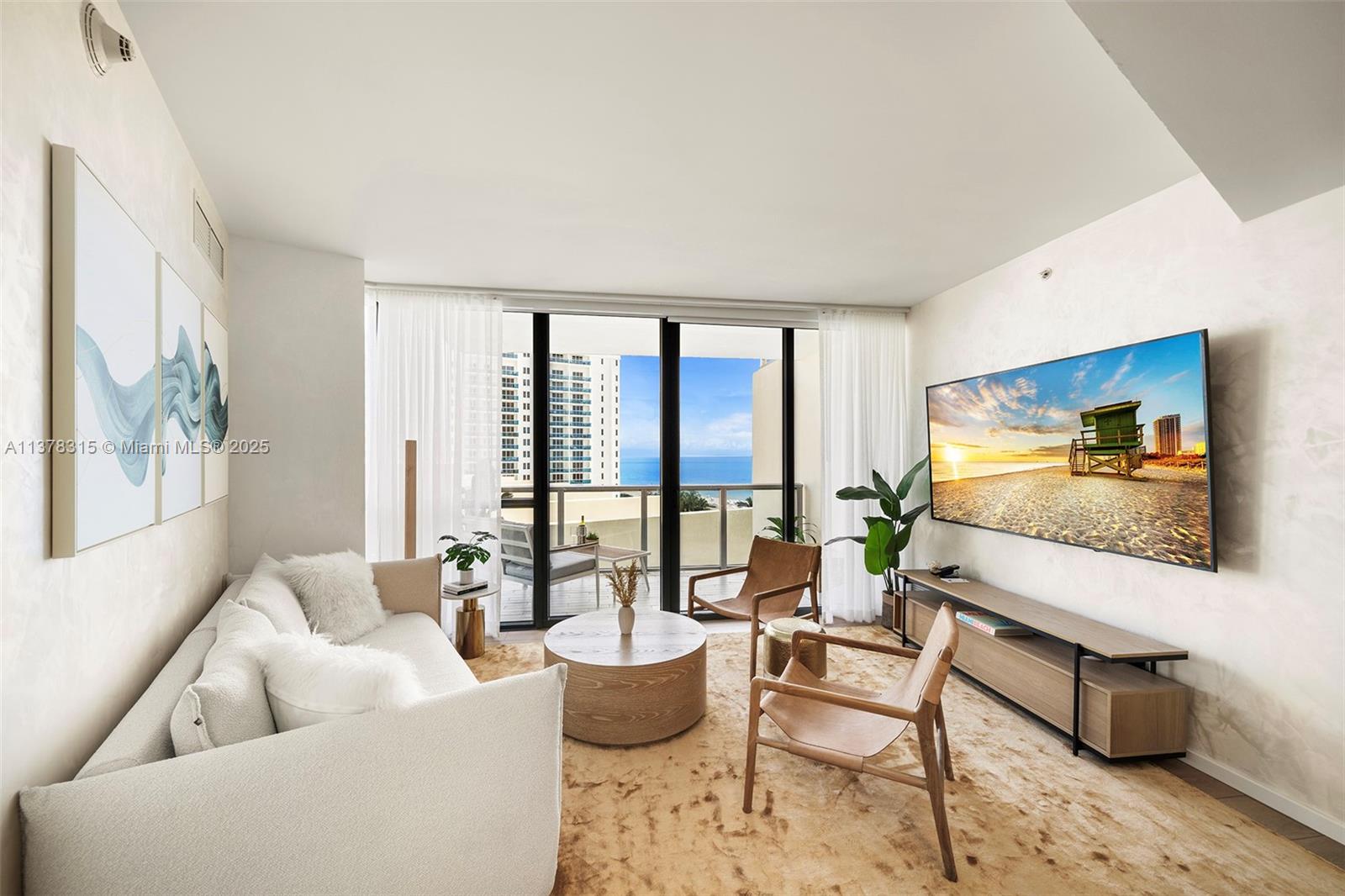 A living room features a sofa, two chairs, a coffee table, and a balcony view — 2201 Collins Ave # 811, Miami Beach FL 33139, MIAMI BEACH, FL