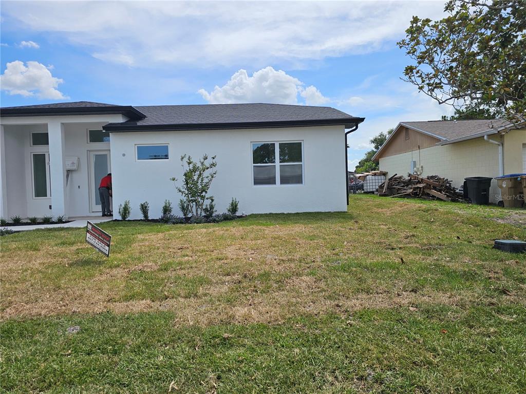 A single-story white house with a black roof, garage, and front entryway — 292 GARDENIA ROAD, KISSIMMEE, FL