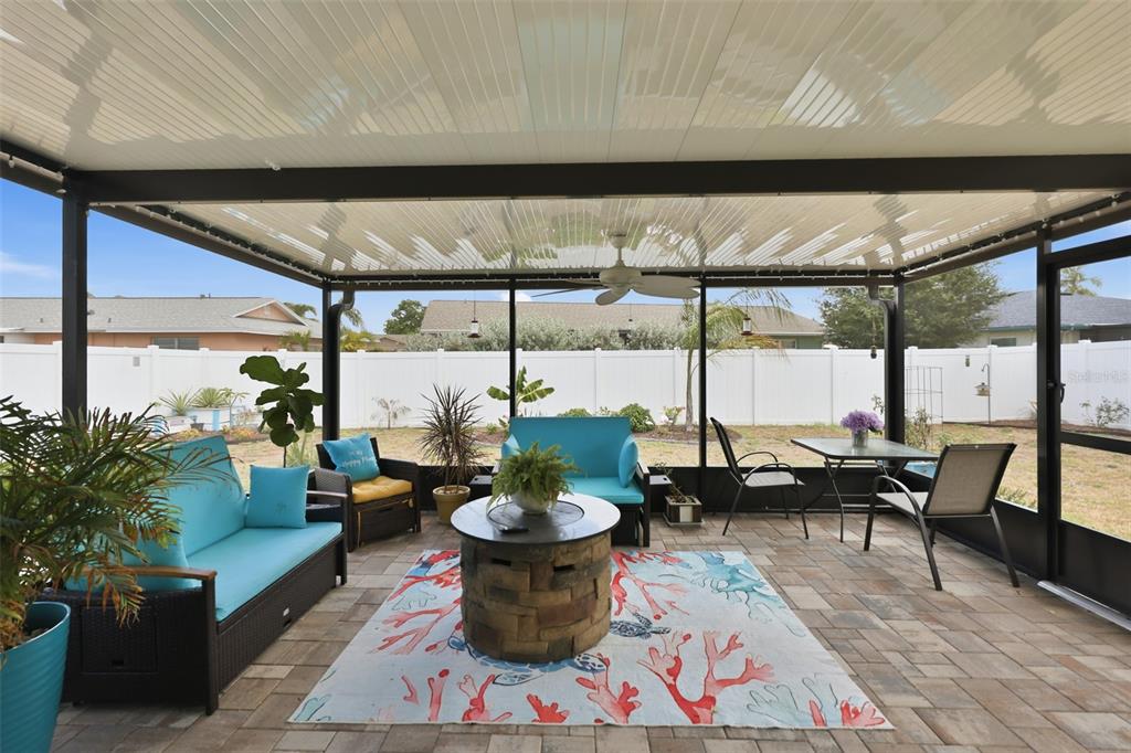 A screened-in patio features a paver floor, a fire pit, and outdoor furniture — 1739 COCO PALM CIRCLE, SUN CITY CENTER, FL