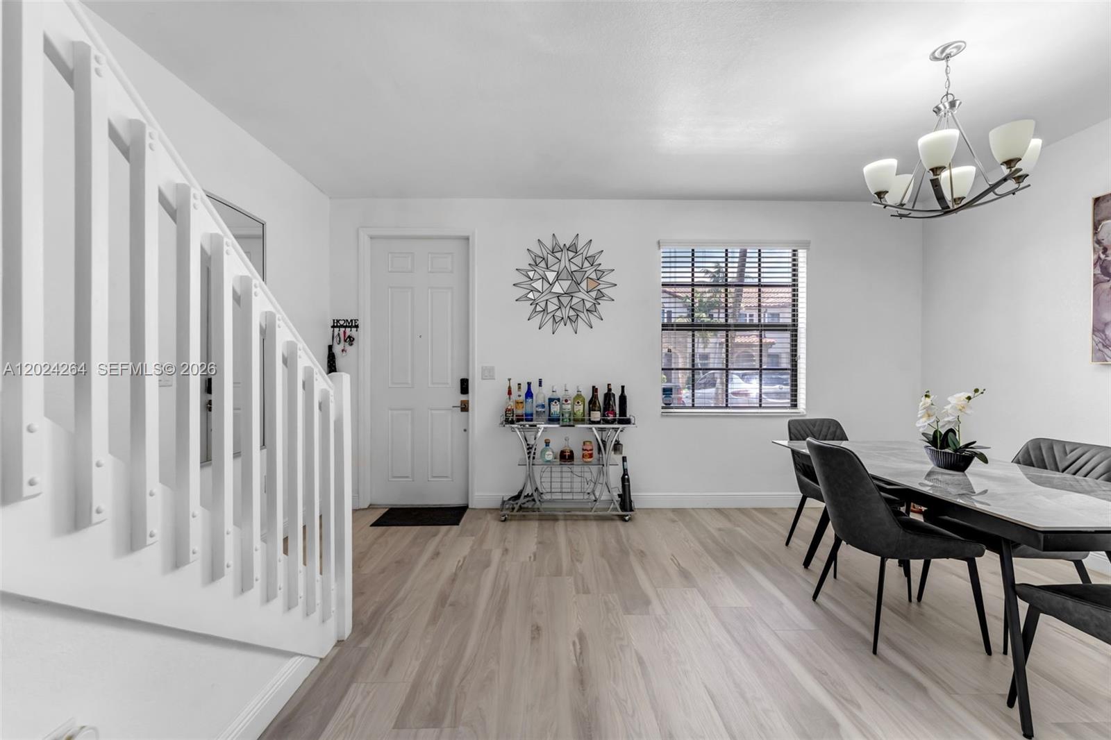 A dining area features a marble-topped table, a bar cart, and a white staircase — 3214 SE 4th Ct, Homestead FL 33033, HOMESTEAD, FL