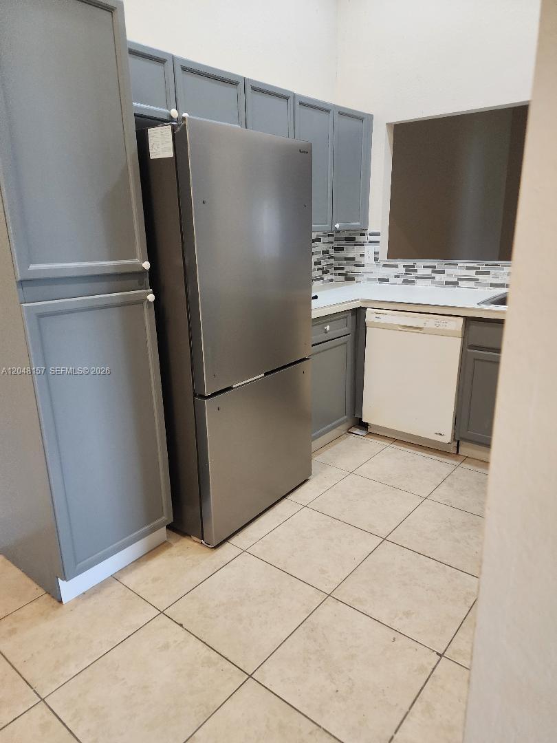 A kitchen features gray cabinets, a stainless steel refrigerator, and a white dishwasher — 4740 SW 14, Lehigh Acres FL 33973, LEHIGH ACRES, FL