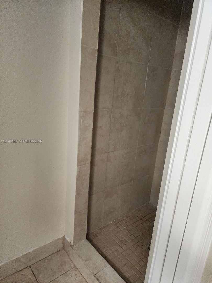 A walk-in shower features beige tiled walls and a small mosaic tile floor — 4740 SW 14, Lehigh Acres FL 33973, LEHIGH ACRES, FL
