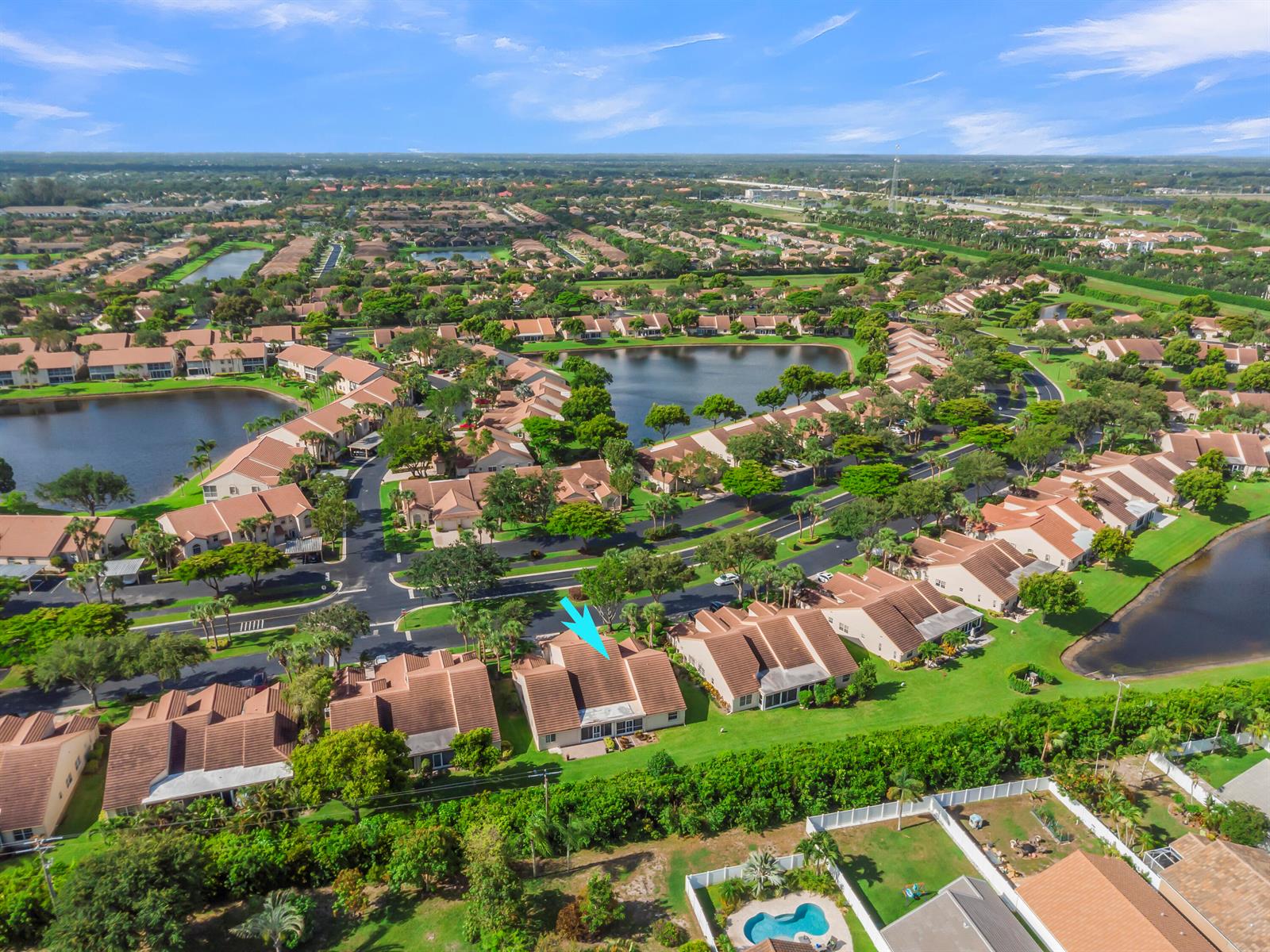 An aerial view shows a residential neighborhood with townhomes, lakes, and landscaped green spaces — 7773 Silver Lake Drive, Delray Beach FL 33446, DELRAY BEACH, FL