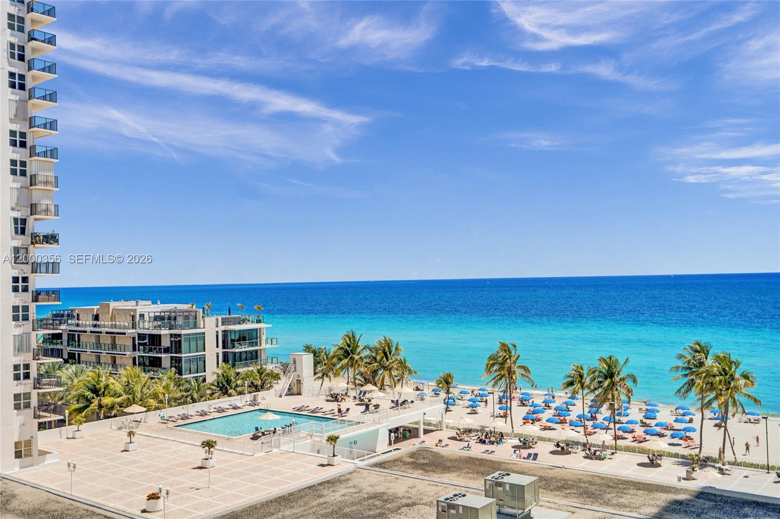 An elevated view shows a swimming pool, beach umbrellas, palm trees, and the ocean — 2401 S Ocean Dr, Hollywood FL 33019, HOLLYWOOD, FL
