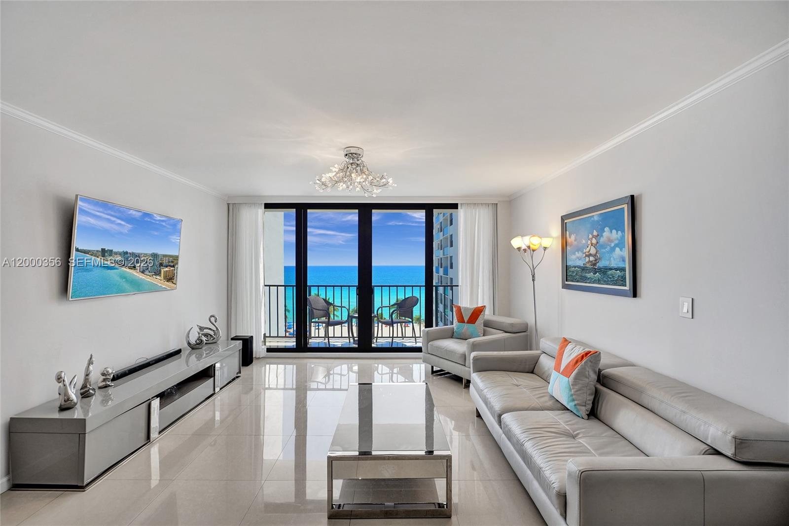 A bright living room features light tile floors, a leather sofa, and a balcony view — 2401 S Ocean Dr, Hollywood FL 33019, HOLLYWOOD, FL