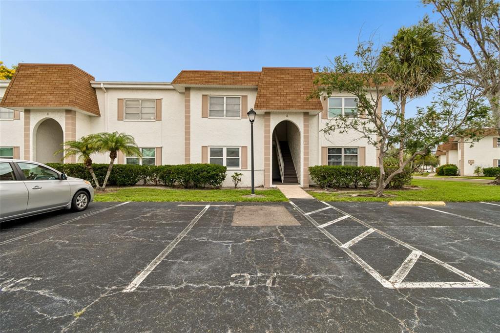 A two-story apartment building with a parking lot in the foreground — 239 S MCMULLEN BOOTH ROAD UNIT 37, CLEARWATER, FL