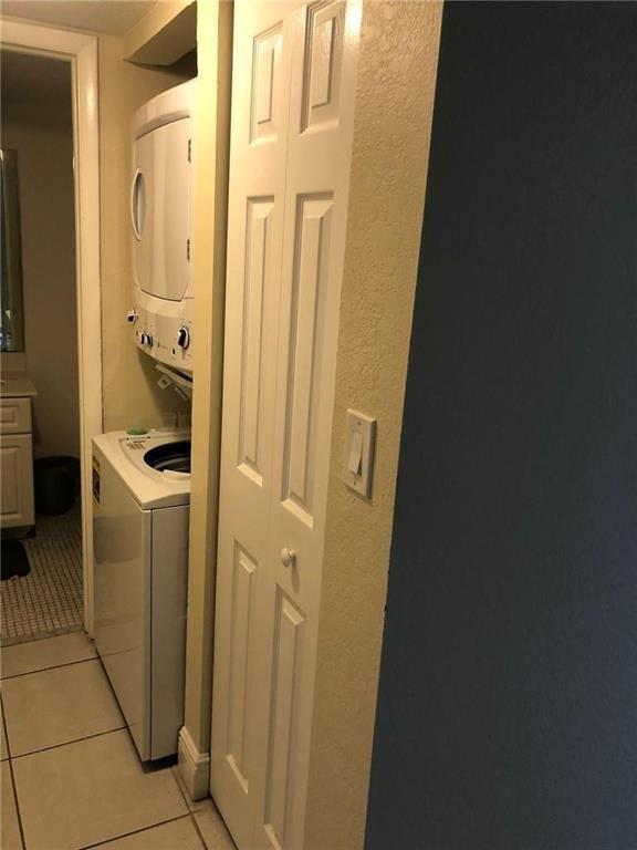 A stacked washer and dryer unit sits next to a white bifold closet door — 10411 N Kendall Drive # B203, Miami FL 33176, MIAMI, FL
