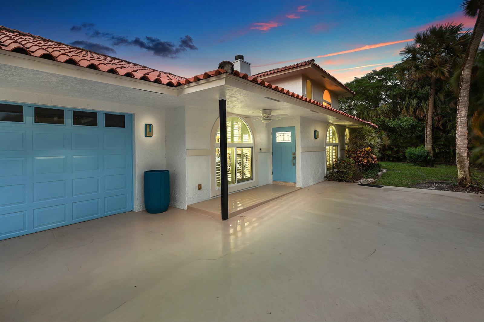 A white house with a blue garage door and front door under a tiled roof — 359 E Ocean Avenue, Lantana FL 33462, LANTANA, FL