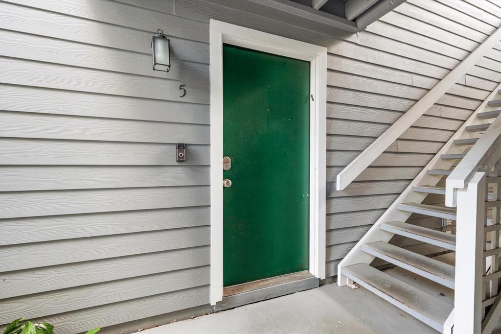 A green front door with the number five is next to an outdoor staircase — 606 S ALBANY AVENUE UNIT 5, TAMPA, FL