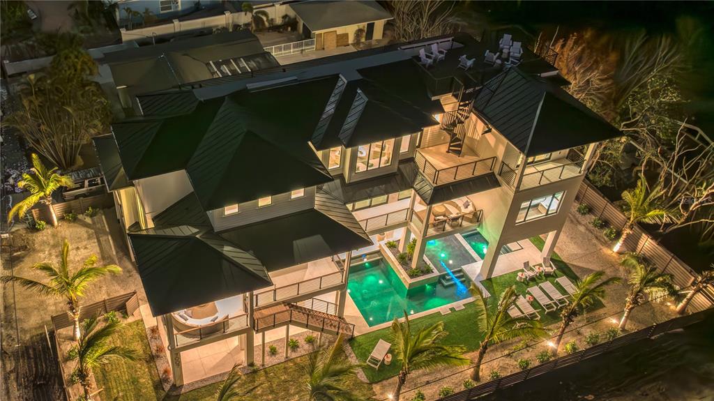An aerial view of a multi-story house at night featuring a pool and landscaped yard — 7007 POINT OF ROCKS ROAD, SARASOTA, FL