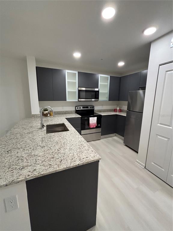 A long, brightly lit hallway features white walls, light tile flooring, and several doors — 5579 MILLENIA PARK UNIT 517, ORLANDO, FL