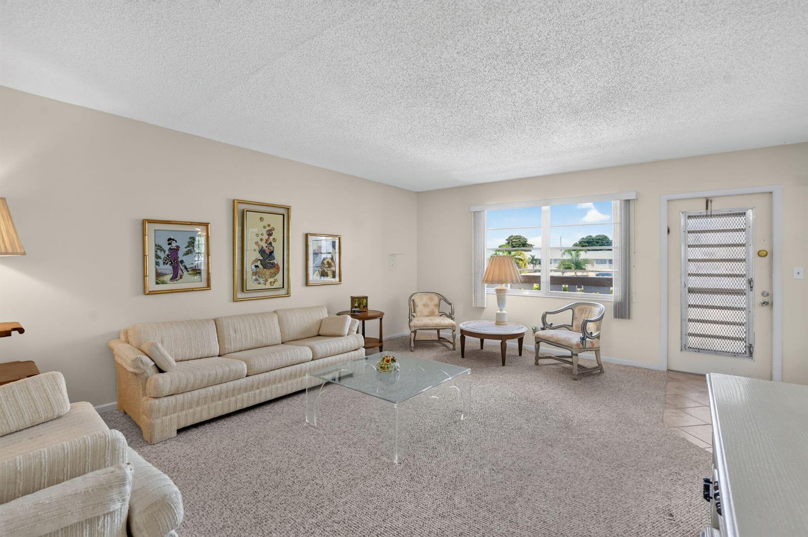 A living room features beige carpet, a cream sofa, two armchairs, and a glass coffee table — 2049 Ventnor O Crescent # 2049, Deerfield Beach FL 33442, DEERFIELD BEACH, FL