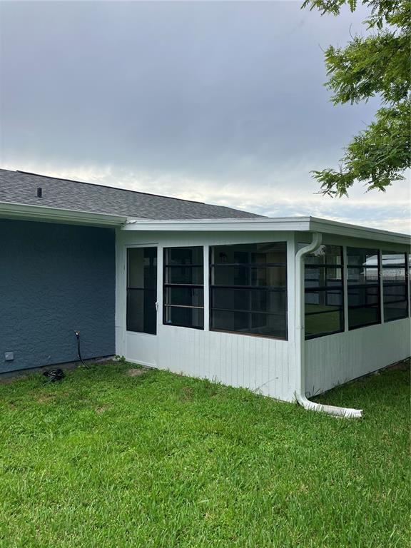 The exterior of a house features a white enclosed sunroom with a screen door — 7570 BERWICK STREET, NORTH PORT, FL