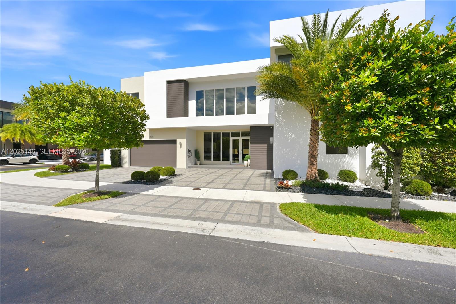 A modern two-story house features a white facade, a paved driveway, and two large trees — 7525 NW 103rd Pl, Doral FL 33178, DORAL, FL