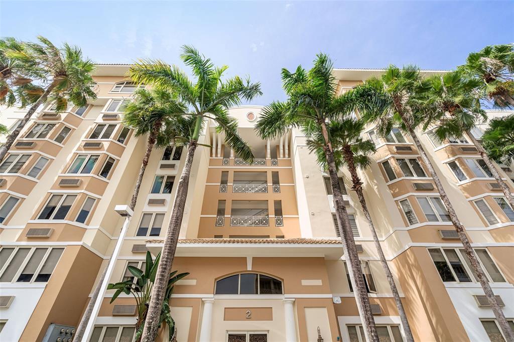 A low-angle view of a multi-story tan apartment building with palm trees in front — 1 PALMA REAL AVE. UNIT 2 A6, GUAYNABO, PR