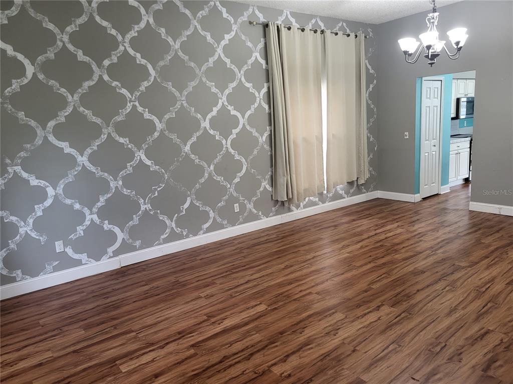 A kitchen features white cabinets, tiled countertops, a center island, and bright blue walls — 1188 FOXFORREST CIRCLE, APOPKA, FL