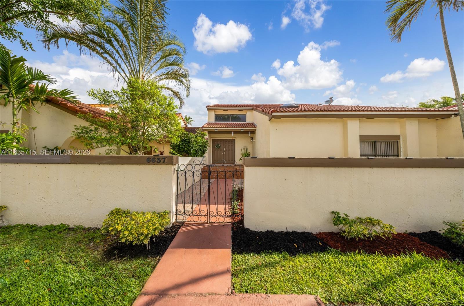 A single-story house features a gated courtyard entrance, a tiled roof, and palm trees — 6637 NW 181st Ln, Hialeah FL 33015, HIALEAH, FL