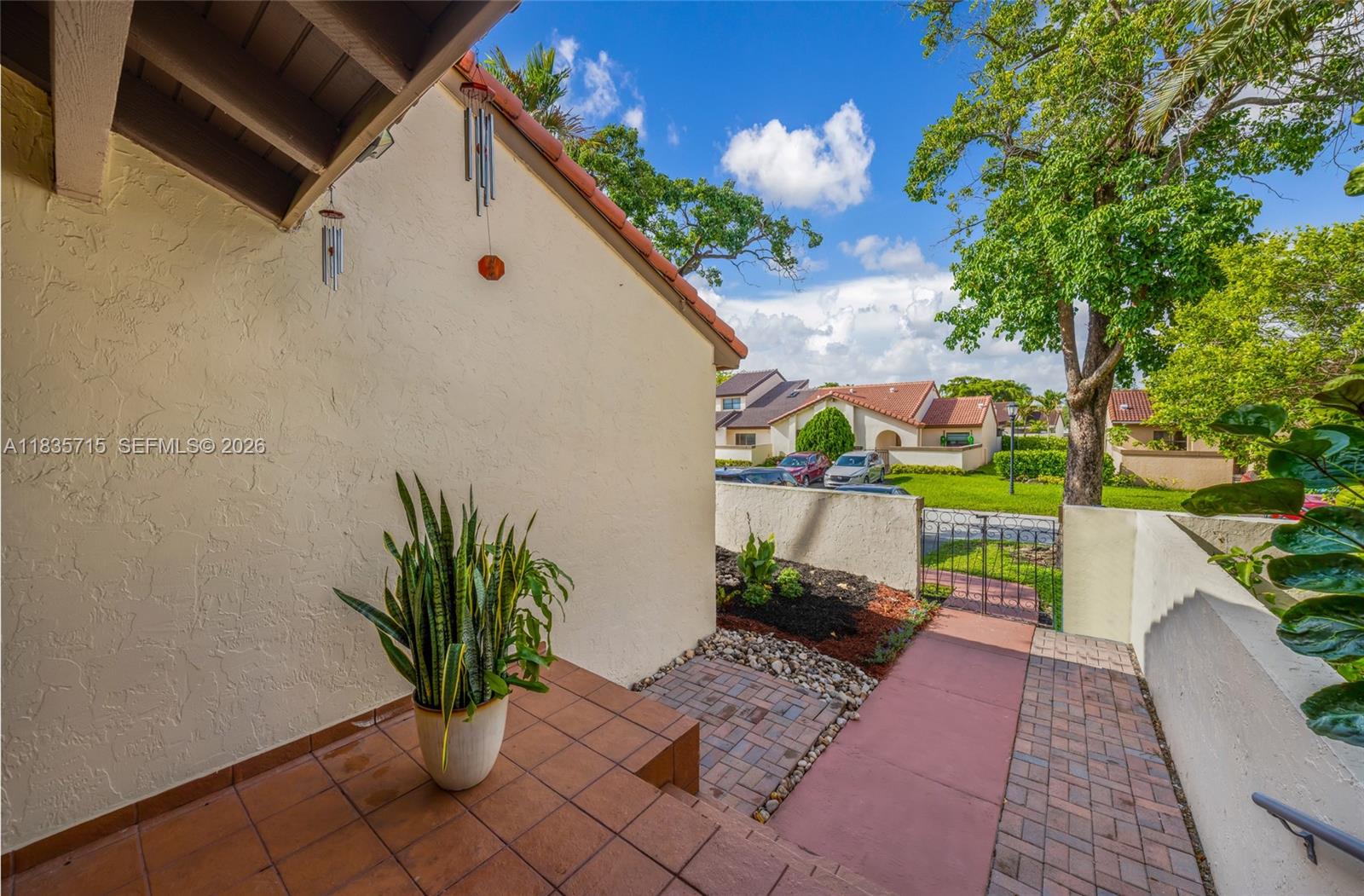 A tiled entryway leads to a walkway with a small garden and metal gate — 6637 NW 181st Ln, Hialeah FL 33015, HIALEAH, FL