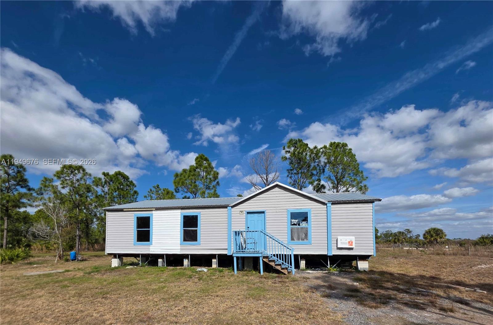 A single-story manufactured home with light gray siding sits on a raised foundation — 8357 Strasse Blvd, Punta Gorda FL 33982, PUNTA GORDA, FL