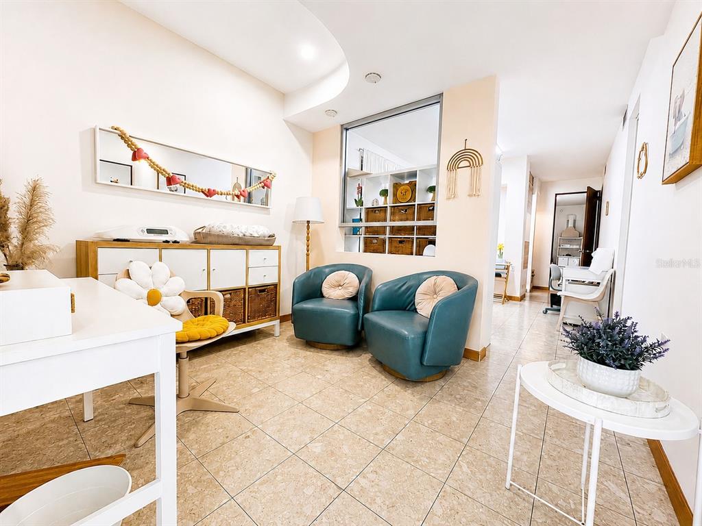 A room features two teal armchairs, a white storage unit, and tile flooring — ACERINA #7 URB. MUÑOZ RIVERA (AVE. MARTINEZ NADAL) UNIT LOCAL A, GUAYNABO, PR