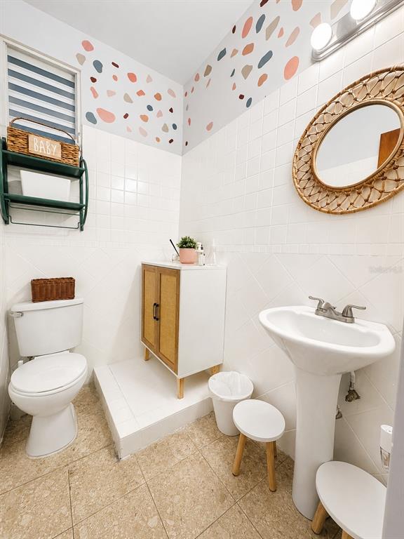 A bathroom features a pedestal sink, a toilet, a vanity, and walls with terrazzo-style decals — ACERINA #7 URB. MUÑOZ RIVERA (AVE. MARTINEZ NADAL) UNIT LOCAL A, GUAYNABO, PR