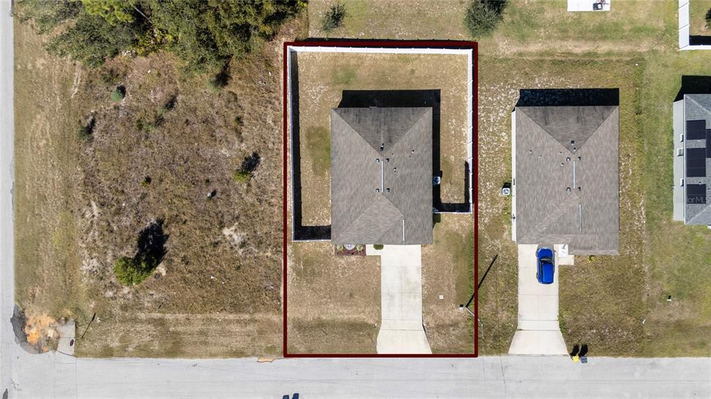 An aerial view shows a single-family home with a fenced backyard and a concrete driveway — 282 FIG COURT, KISSIMMEE, FL