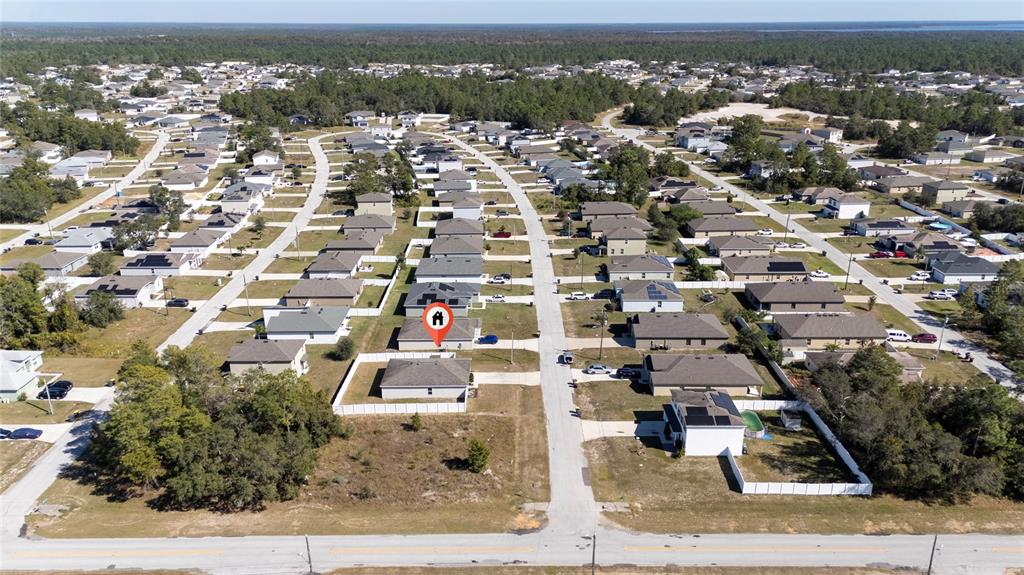 An aerial view shows a suburban neighborhood with a marked single-family home and fenced yards — 282 FIG COURT, KISSIMMEE, FL