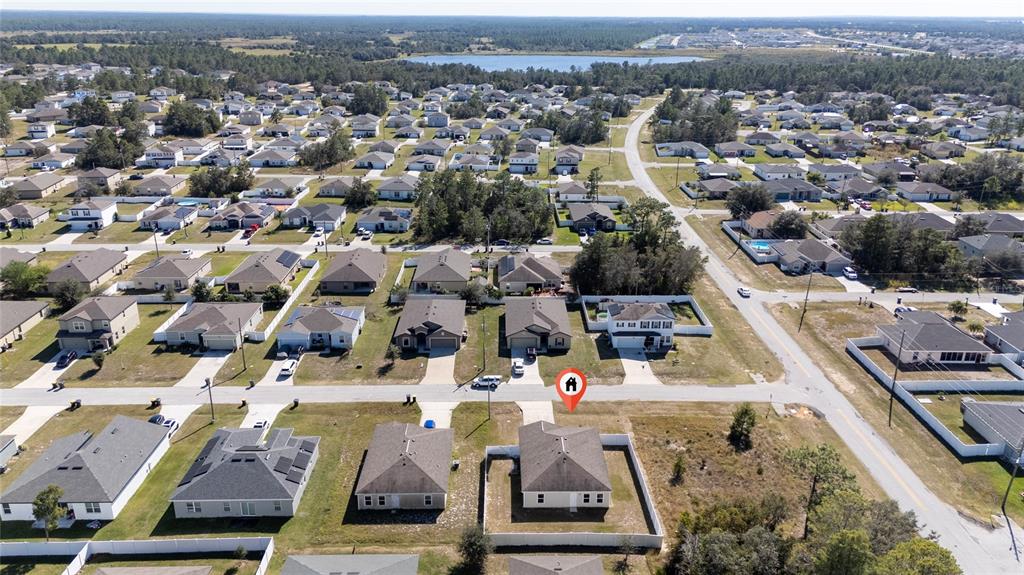 An aerial view shows a suburban neighborhood with single-family homes and a marked property — 282 FIG COURT, KISSIMMEE, FL